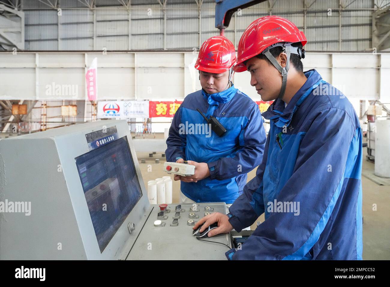 (230131) -- ZHUHAI, 31. Januar 2023 (Xinhua) -- Mitarbeiter manipulieren eine Maschine, um Beton in den Tauchschlauch E23 der Shenzhen-Zhongshan Autobahn Unterwassertunnel in einer Tauchrohrfabrik von CCCC Fourth Harbour Engineering Co., Ltd. Auf Niutou Island, Zhuhai, Südchina's Provinz Guangdong, 30. Januar 2023. Die Vorfertigung von E23, dem letzten Tauchrohr (nicht standardisiertes Rohr, einschließlich des letzten Gelenks) eines Unterwassertunnels, eines Abschnitts der Autobahn zwischen Shenzhen und Zhongshan in Guangdong, wurde am Dienstag abgeschlossen. Nach dem Gießen von Beton wird das 164,5 Meter lange Stahlrohr w Stockfoto