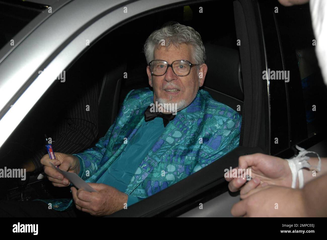 Der australische Musiker, Komponist, Maler und Fernsehmoderator Rolf Harris hält an, um ein Autogramm auf Barbara Windsors Geburtstagsfeier zum 70. Geburtstag im Royal Garden Hotel zu signieren. London, Großbritannien. 8/5/07. Alle Stockfoto