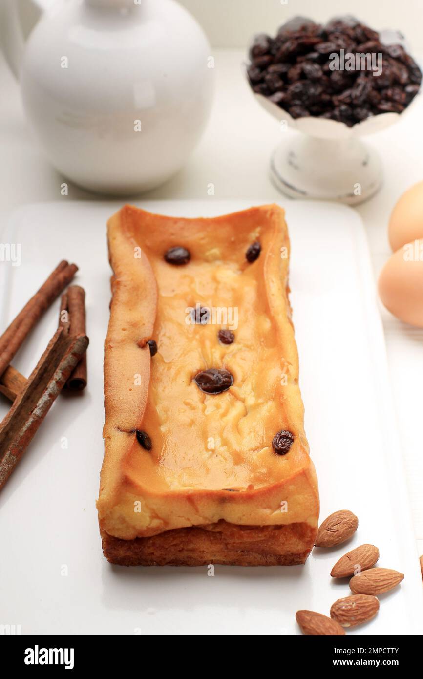 Gebackener Klappertaart, Manado Custard Cake mit holländischem Einfluss. Hergestellt aus Mehl, Kokosnuss, Ei, Zucker und Butter. Garniert mit Rosinen und Zimtpulver Stockfoto