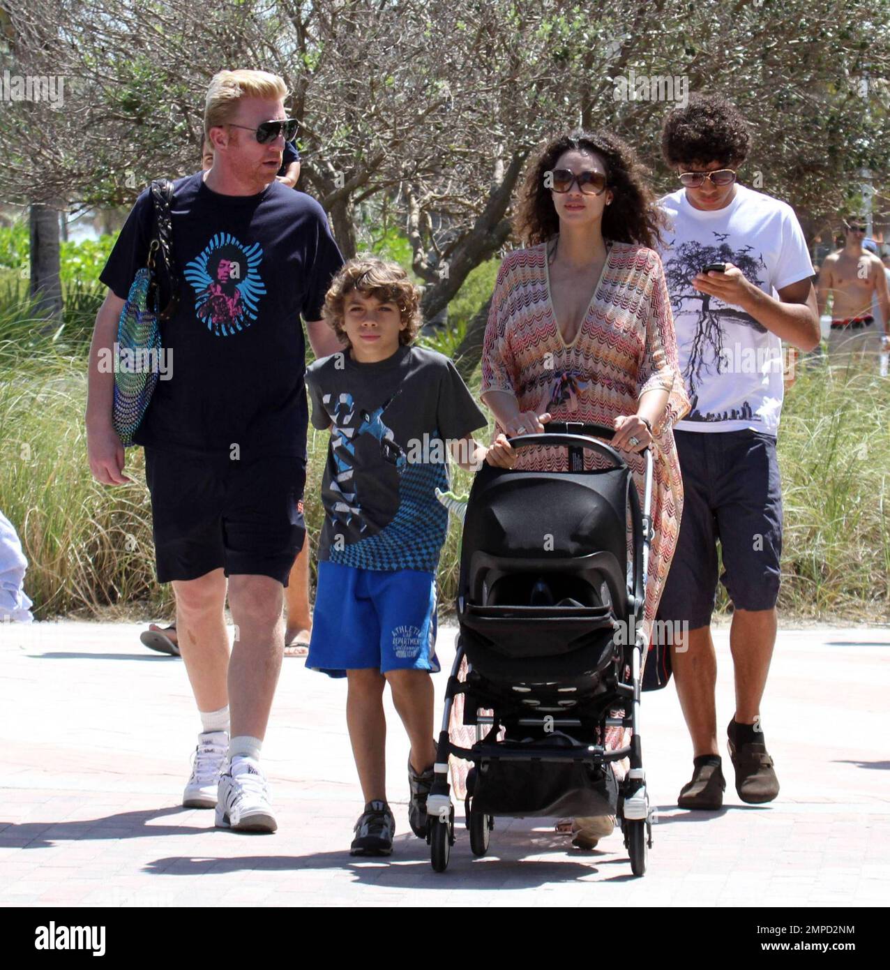 Boris Becker geht mit seiner wachsenden Familie auf der Promenade in South Beach spazieren. Seine Frau Sharlely zeigte ihre Post-Baby-Kurven in einem niedrig geschnittenen Kleid. Elias schien sehr beschützend für seinen neuen Bruder Amadeus zu sein, hielt sich am Buggy fest und half dabei, ihn durch einige enge Räume zu führen. Boris' ältester Sohn Noah ging mit Boris und scheint jetzt größer als sein Vater zu sein. Miami, Florida 3/27/10. L Stockfoto