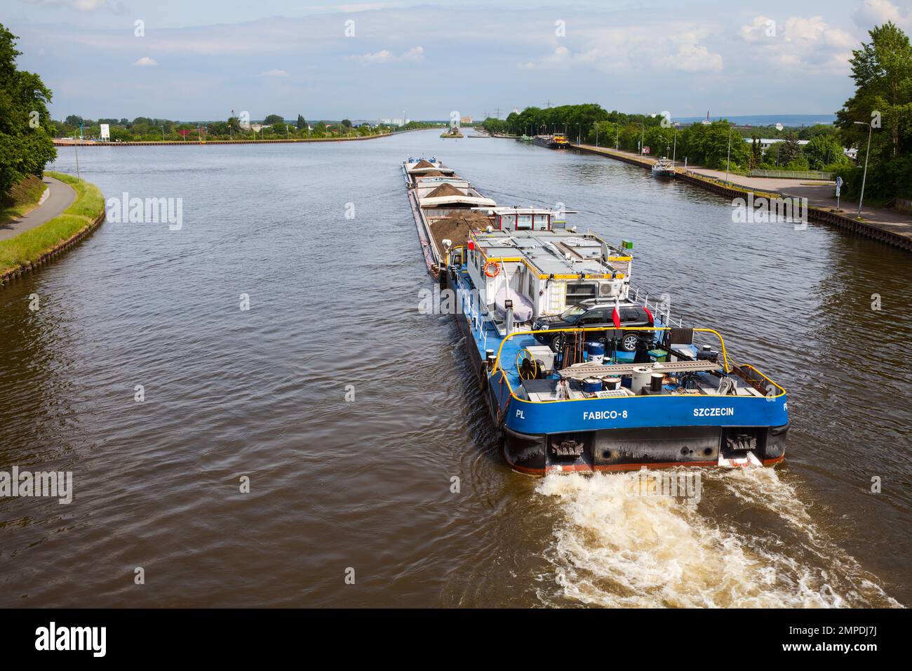 Ein Schleppboot schiebt ein beladenes Schiff in Minden, Mittelland Canal, nach Minden Aqueduct, Minden, Nordrhein-Westfalen, Deutschland Stockfoto