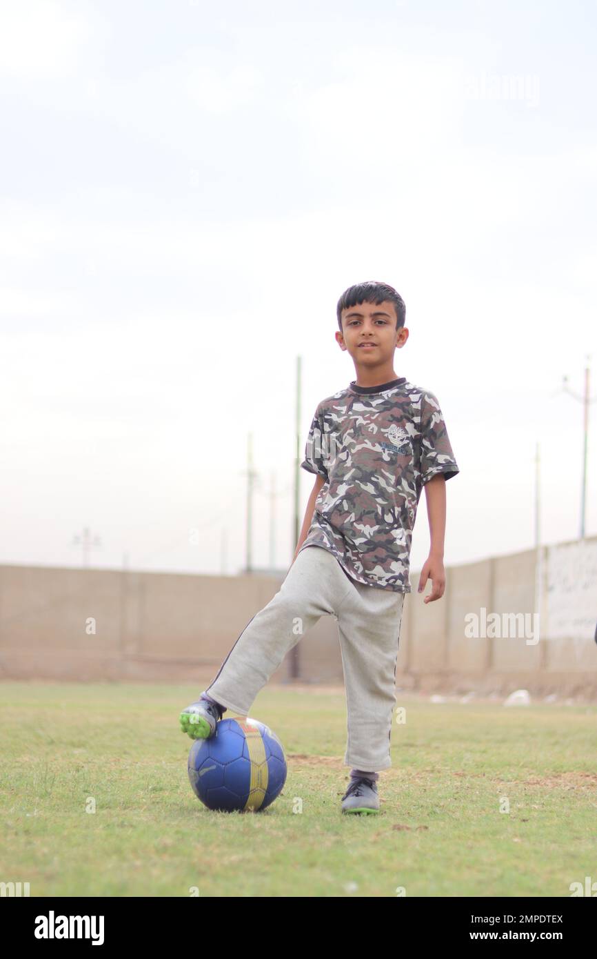 Karatschi Pakistan 2019, ein Kind, das am Sonntagmorgen mit seinem blauen Fußball für ein Foto posiert, asiatische Kinder, lokale Sportarten, Fußball in Pa Stockfoto