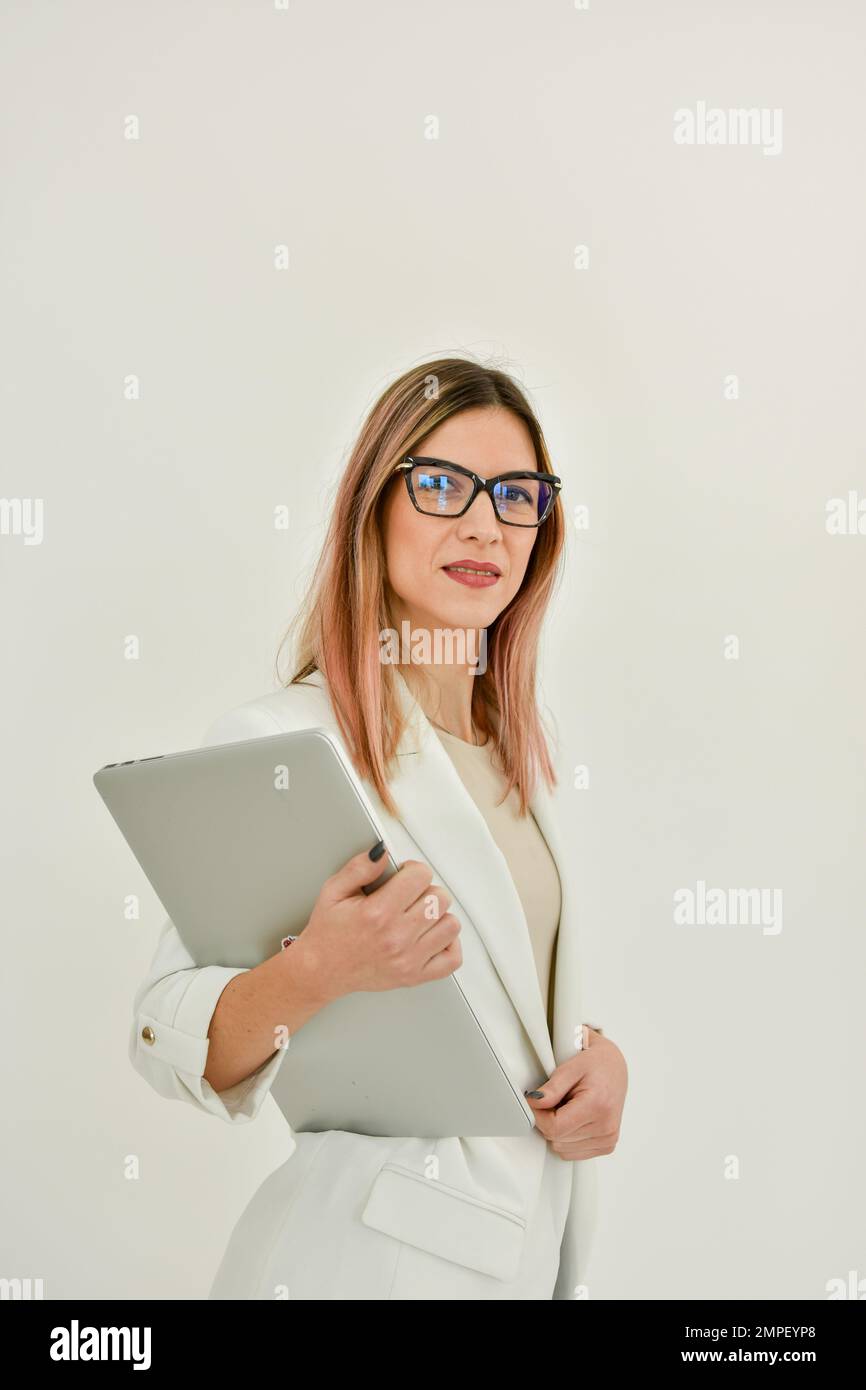Eine Geschäftsfrau in einer weißen Jacke mit einem grauen Laptop. Stockfoto