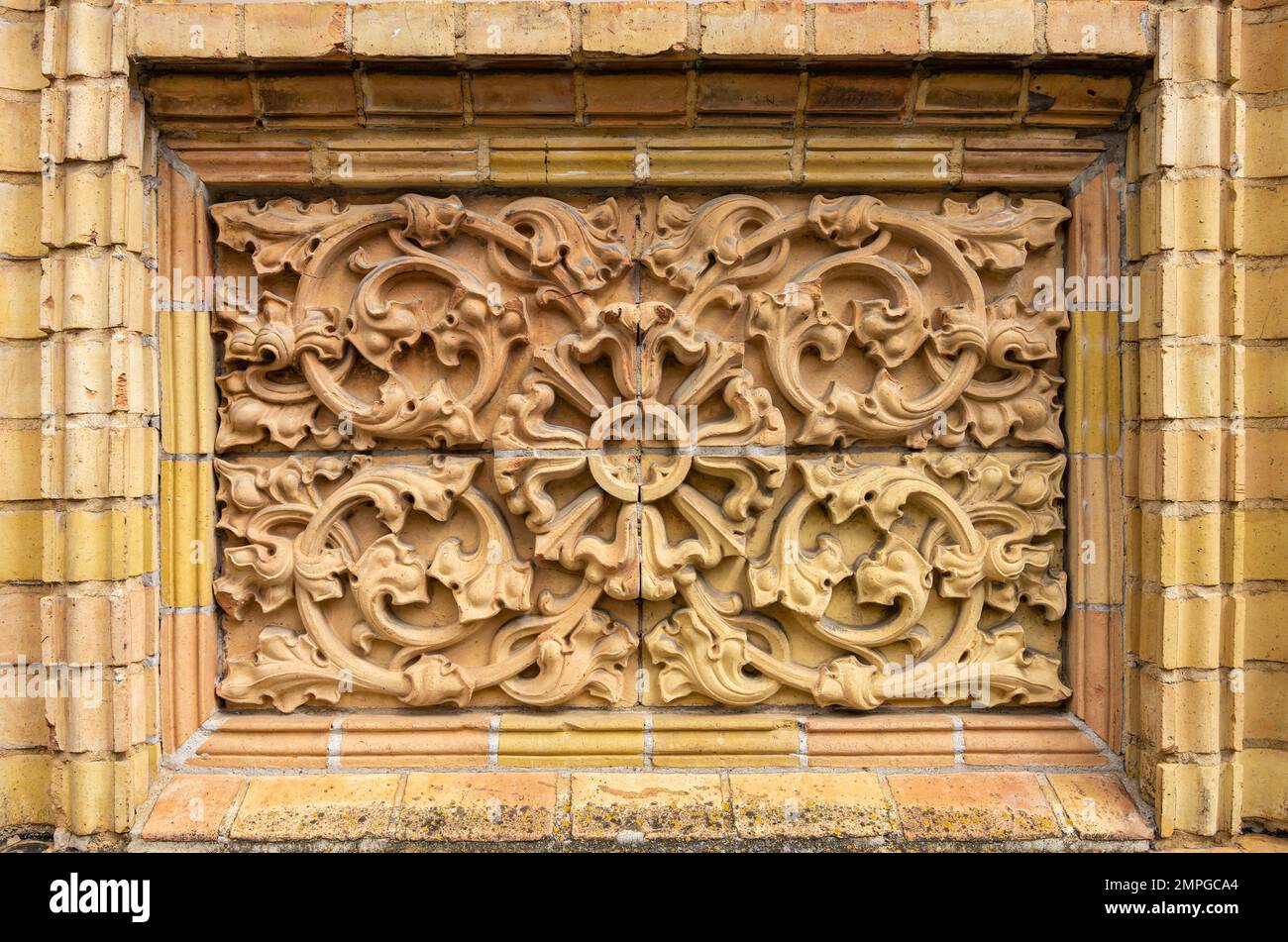 Historische äußere architektonische Details mit Tendril-Ornamenten aus Ziegelmaterial. Stockfoto