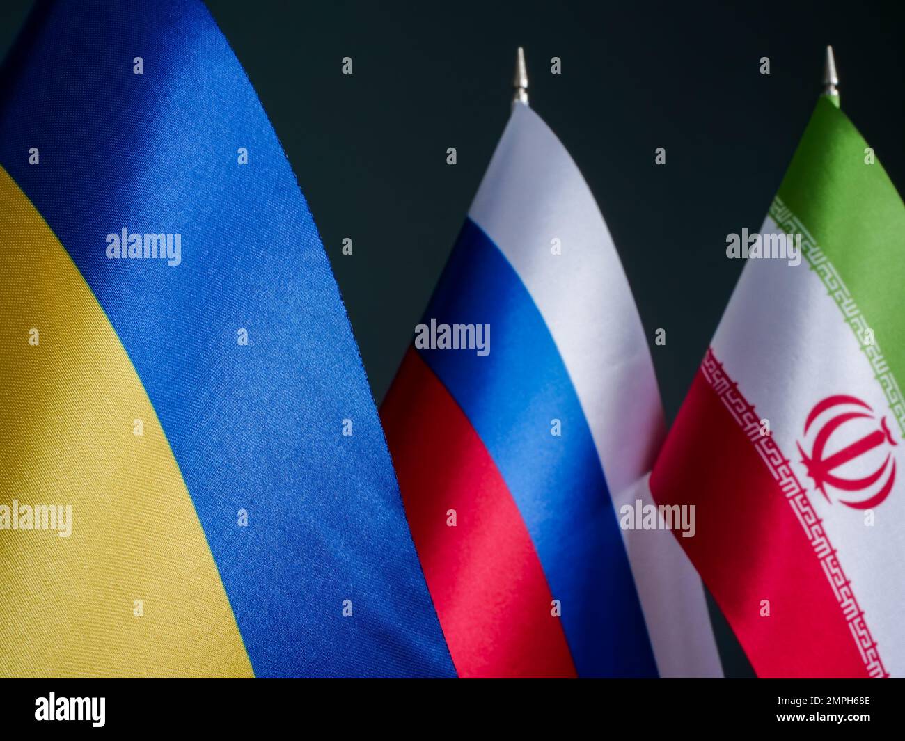 Ukrainische Flagge vor den Flaggen Russlands und Irans als Verbündete. Stockfoto