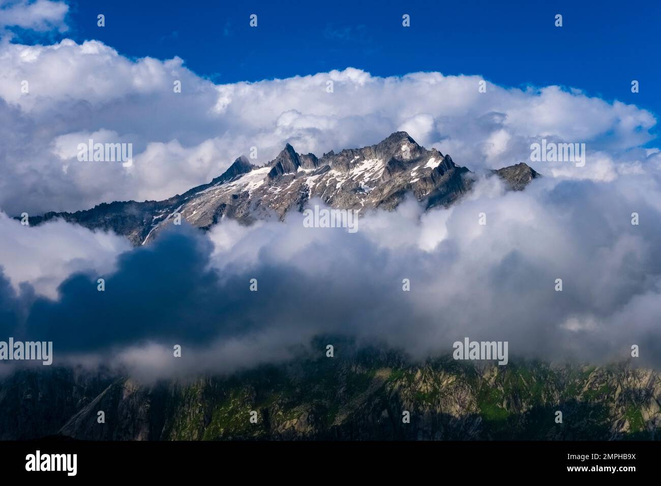 Die Gipfel der Berge Galenstock, Gärstenhörner und Dammastock, die aus den Wolken ragen. Stockfoto