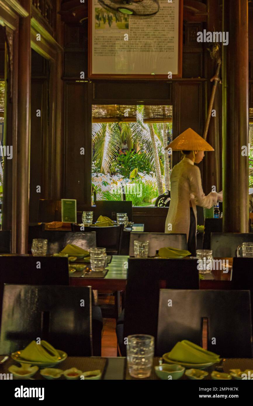 Elegantes asiatisches Luxusrestaurant mit einer Kellnerin in traditioneller Kleidung in Vietnam Stockfoto