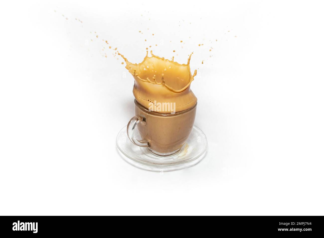 Kronenspritzer auf einer transparenten Kaffeetasse aus Glas mit Milch, isoliert auf weißem Hintergrund Stockfoto