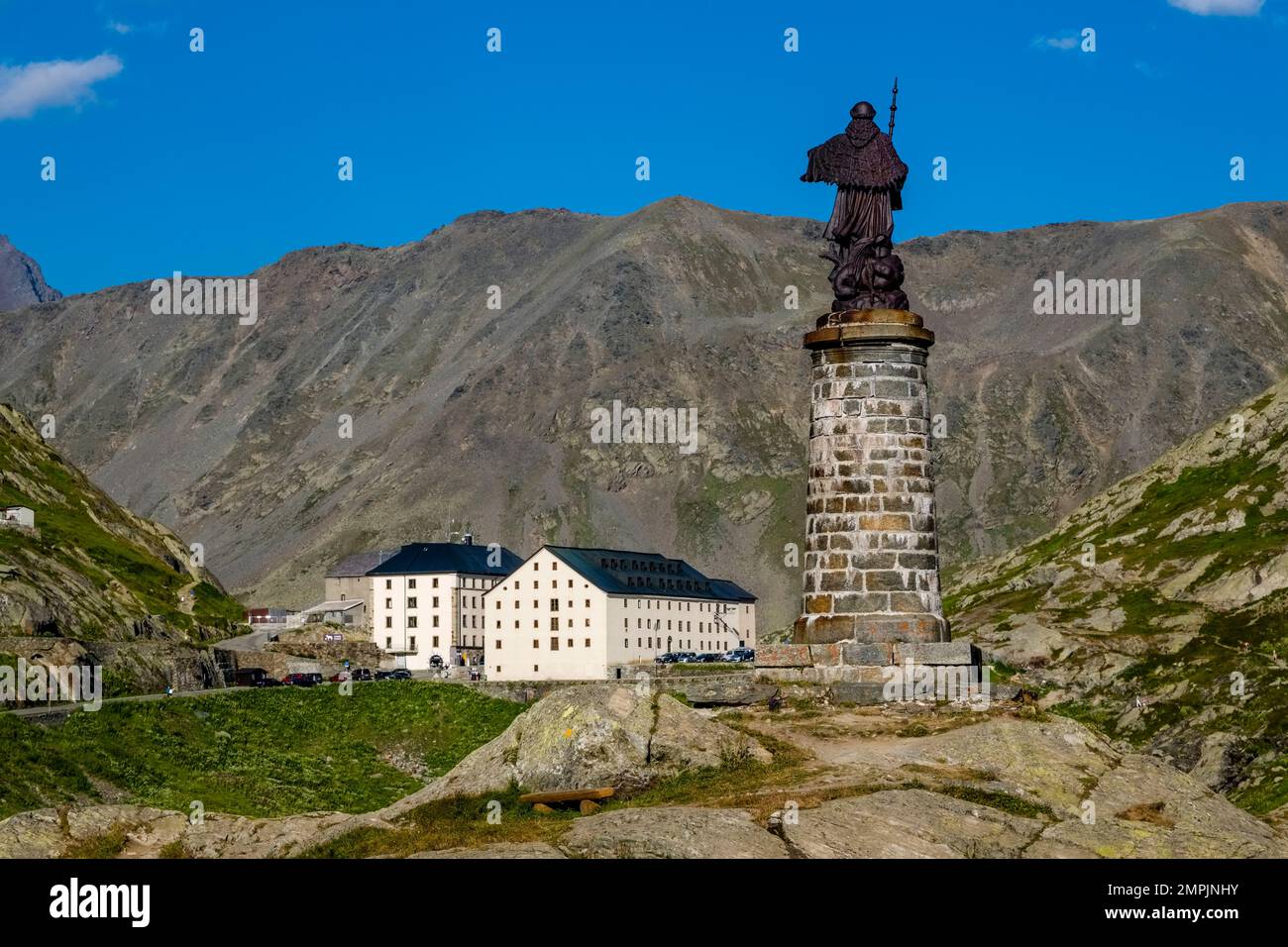 Die Statue von St. Bernard, Gebäude und alpine Landschaft auf dem Great St. Bernard Pass. Stockfoto