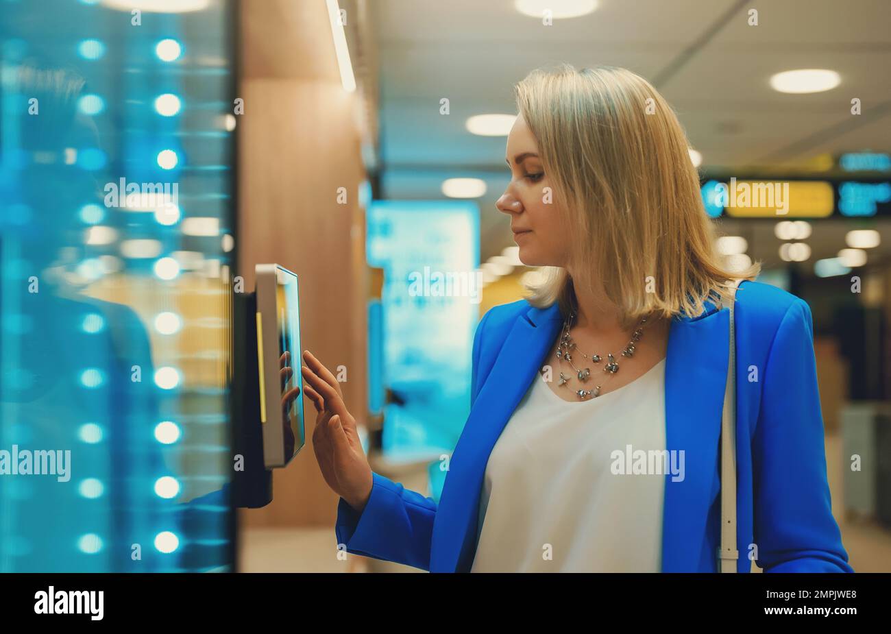 Frau zahlt an Selbstcheckouts im Supermarkt. Stockfoto