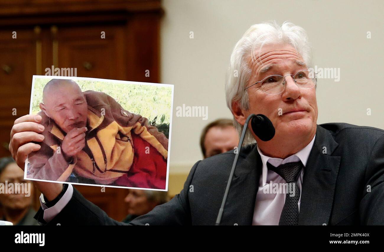 Actor Richard Gere, chairman of the Board of Directors of the International Campaign for Tibet, holds up an image of a Tibetan monk who recently self-immolated as he testifies during a House Foreign Affairs, Asia and the Pacific Subcommittee hearing on Capitol Hill in Washington, Wednesday, Dec. 6, 2017. (AP Photo/Carolyn Kaster) Stockfoto