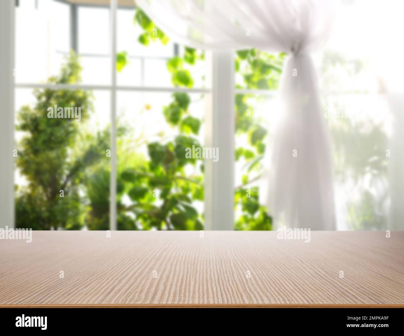 Leerer Holztisch vor dem Fenster. Sonniger Morgen Stockfoto