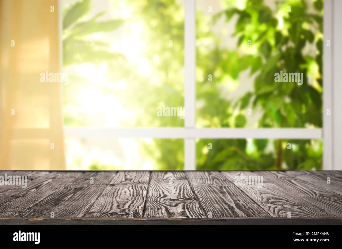 Leerer Holztisch vor dem Fenster. Sonniger Morgen Stockfoto