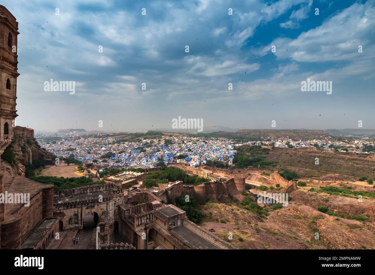 Blick auf die Festung Mehrangarh mit Fernsicht auf die blaue Stadt Jodhpur, Rajasthan, Indien. Das historische Fort ist UNESCO-Weltkulturerbe. Blauer Himmel, Wolken. Stockfoto