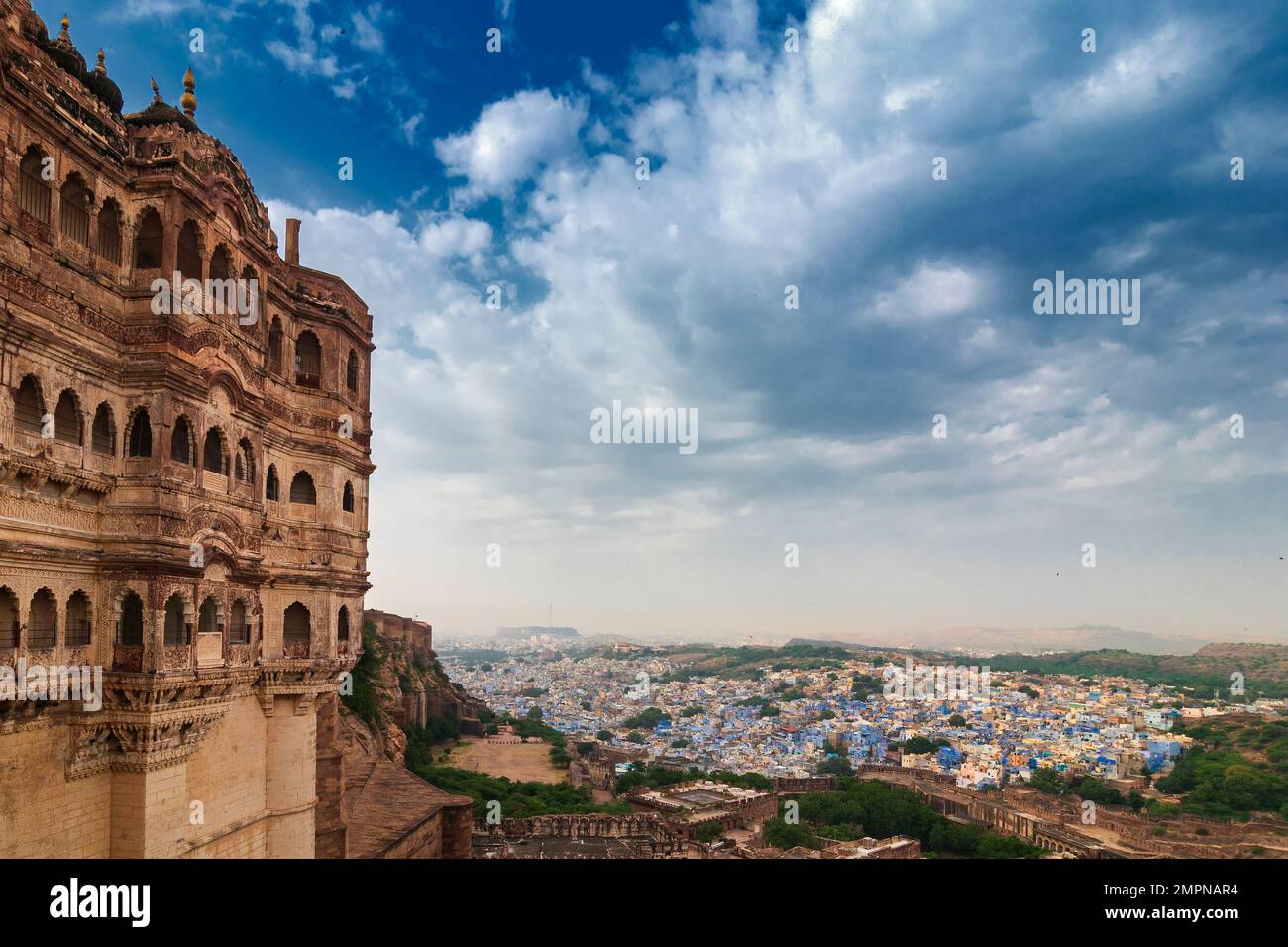 Blick auf die Festung Mehrangarh mit Fernsicht auf die blaue Stadt Jodhpur, Rajasthan, Indien. Das historische Fort ist UNESCO-Weltkulturerbe. Blauer Himmel, Wolken. Stockfoto