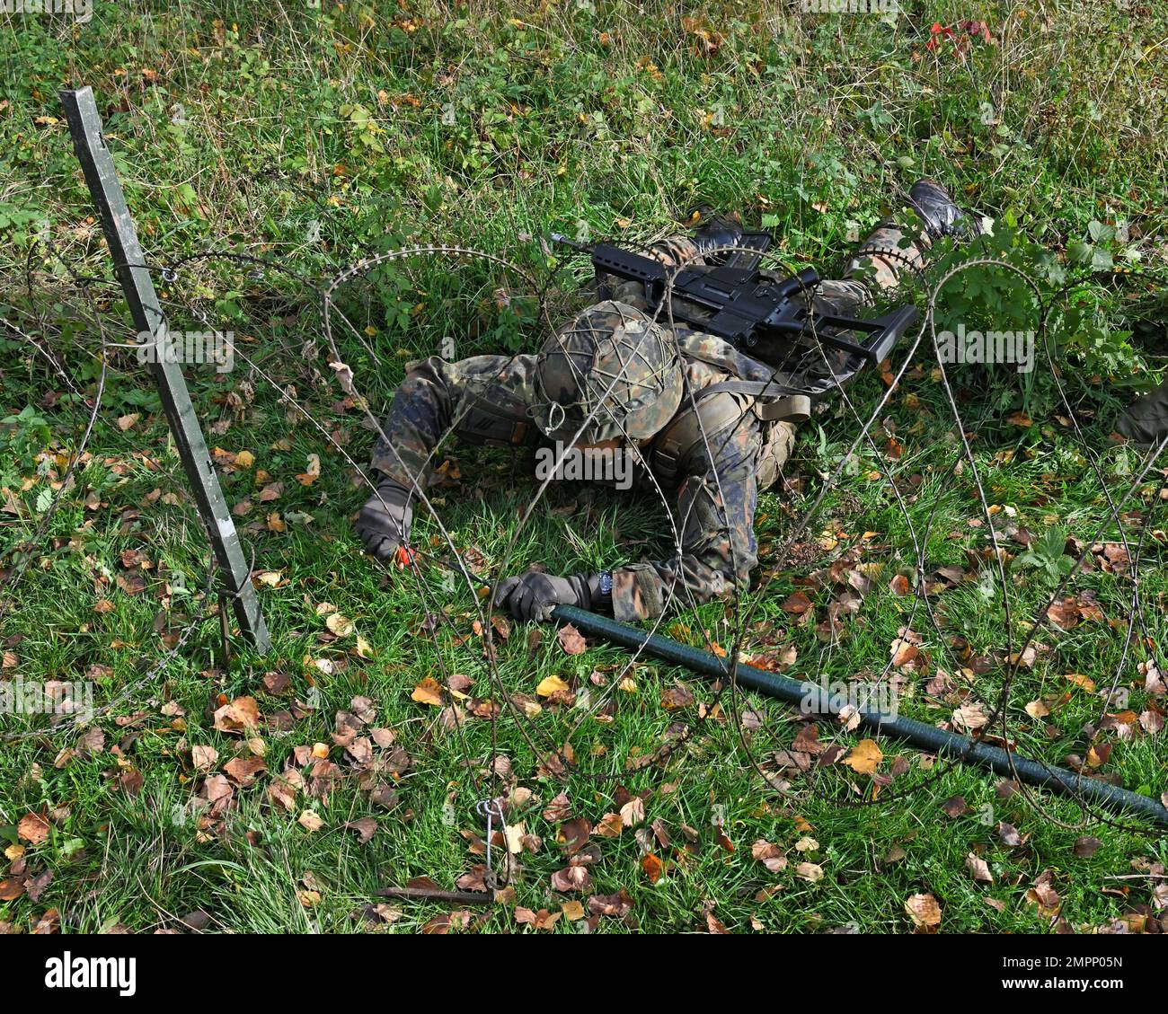 Ein deutscher Fallschirmjäger (Bundeswehr) mit der 4. Kompanie/Fallschirmjaeger, Regiment 26, trainiere, wie man einen Stacheldraht sprengt, bevor man ein vom Feind besetztes Gebäude angreift, während einer städtischen Geländekampfübung in Smith Barrack in Baumholder, Deutschland, am 08. November 2022. Die Einheit trainierte in der Vorbereitung auf zukünftige Übungen und Szenarien für die Bewegung über das städtische Terrain Village. Stockfoto