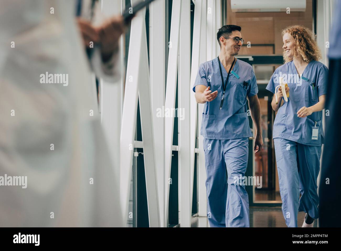 Lächelndes männliches und weibliches Gesundheitspersonal im Flur des Krankenhauses Stockfoto