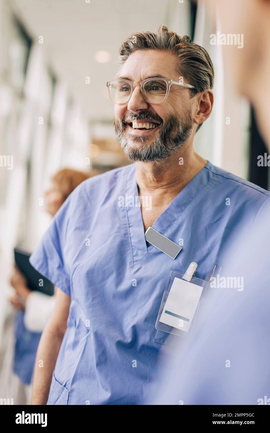 Glücklicher, reifer Arzt in Kittel im Krankenhaus Stockfoto