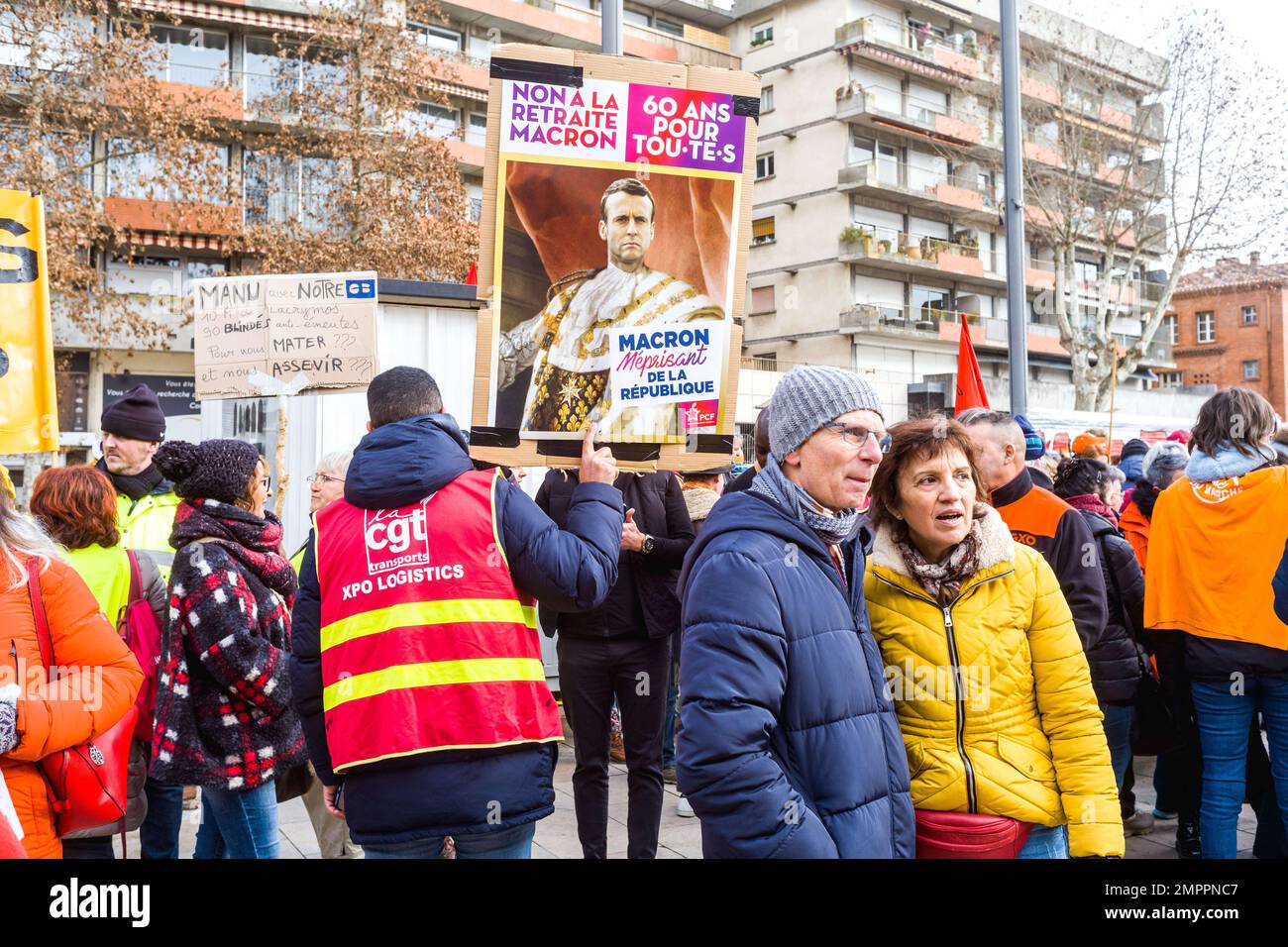 Ein Mann mit einem CGT Transports, XPO Logistics Chasuble, mit einem Poster, Nein zum Macron-Ruhestand, 60 Jahre für alle, PCF. Tag des Streiks und der Demonstration, einberufen durch die Versammlung (CFDT, CGT, FO, CFE-CGC, CFTC, UNSA, Solidaires, FSU), um gegen den Plan der Regierung zu protestieren, das gesetzliche Renteneintrittsalter von 62 auf 64 Jahre anzuheben. Frankreich, Montauban am 31. Januar 2023. Foto: Patricia Huchot-Boissier/ABACAPRESS.COM Stockfoto