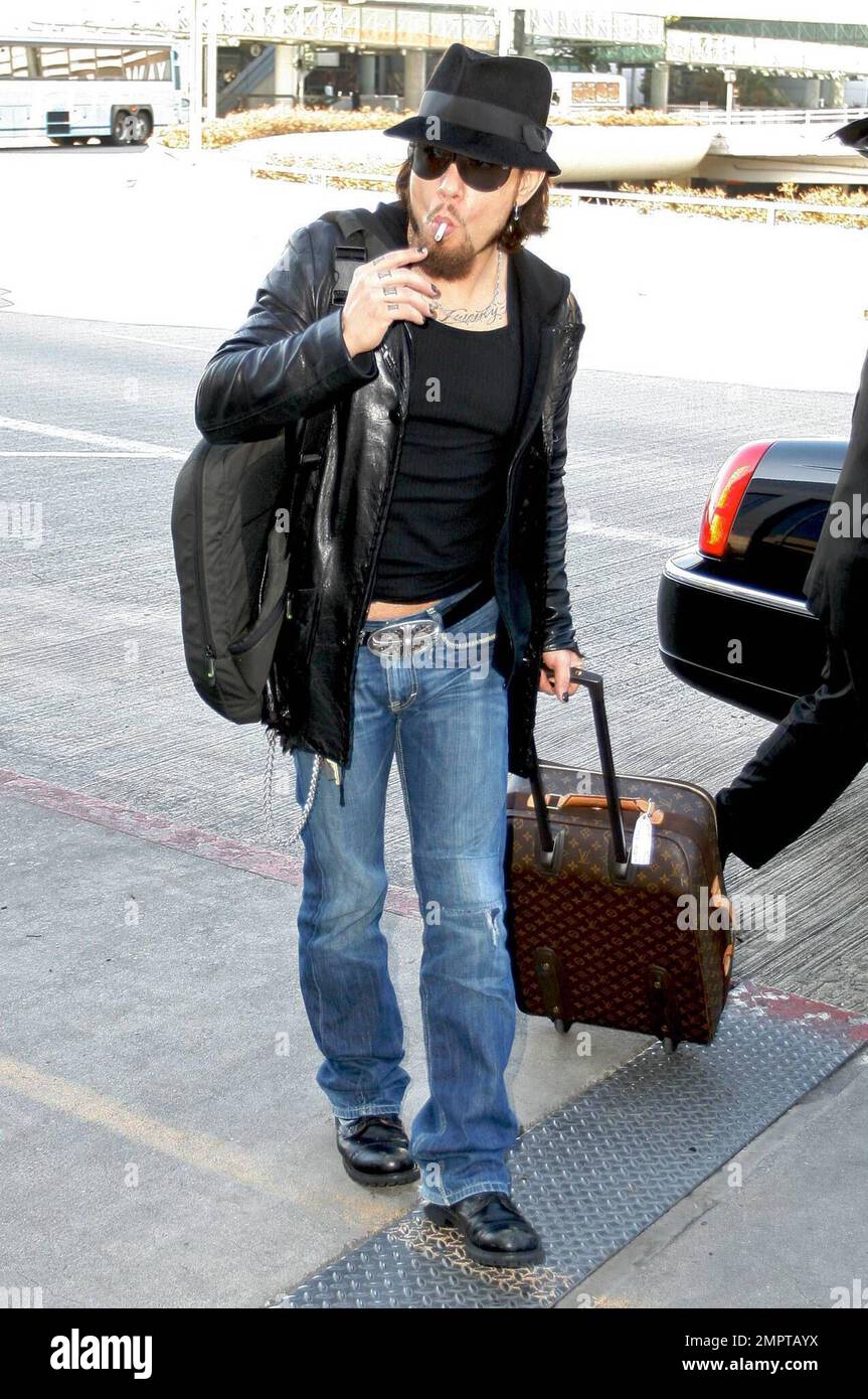 Exklusiv!! Dave Navarro raucht gern, bevor er vom Los Angeles International Airport abfliegt. Dave entschied sich für ein sehr legeres Outfit für den Flug. Er trug ein eng anliegendes T-Shirt, das seinen Bauch zeigt, eine Lederjacke und blaue Jeans und fügte seinem Louis Vuitton Gepäck einen zusätzlichen Stil hinzu. Los Angeles, Kalifornien. 12/05/08. Stockfoto