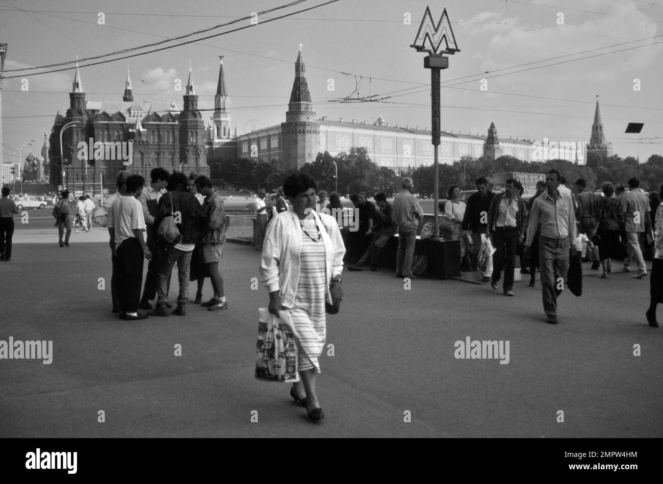 Historischer Archive Street Blick Auf Russische Fußgänger, Muscovites Walking In Manege Square Neben Dem Eingang Zur Moskauer Metro Mit Original Metro Schild. Das Staatliche Historische Museum und der Kreml sind im Hintergrund zu sehen, Moskau, Russland 1990 Stockfoto