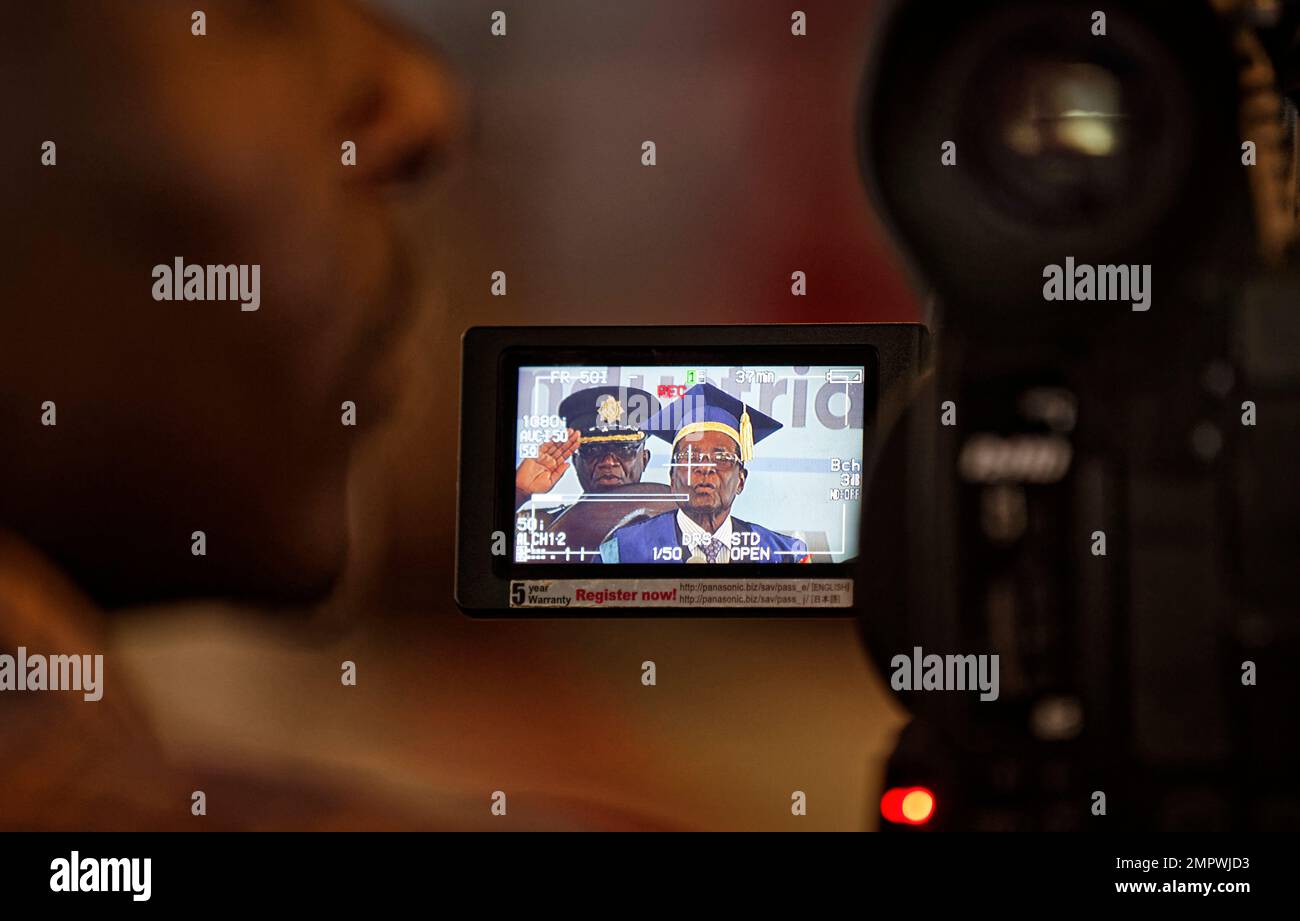 A television cameraman films Zimbabwe's President Robert Mugabe as he