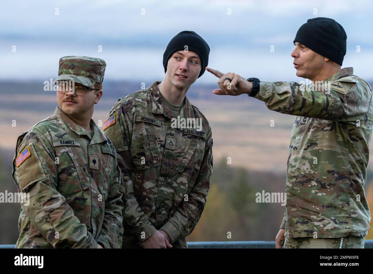 USA Army SPC. Pablo Ramirez, Left, Feuerwehrspezialist, PFC Garrett Robbins, Feuerwehrspezialist, und SFC. Anthony Odell, ein Spezialist für Brandschutz, der der Kampfluftfahrt-Brigade, 1. Panzerdivision, zugewiesen ist, diskutiert Pläne und Verfahren für den bevorstehenden Aufruf zur Brandübung in Grafenwöhr, Deutschland, 19. November 2022. Die Kampfluftfahrtbrigade nahm an einem Live-Aufruf zur Brandübung Teil, um die Letalität und Leistungsfähigkeit unserer Feuerwehrteams zu erhöhen. Stockfoto