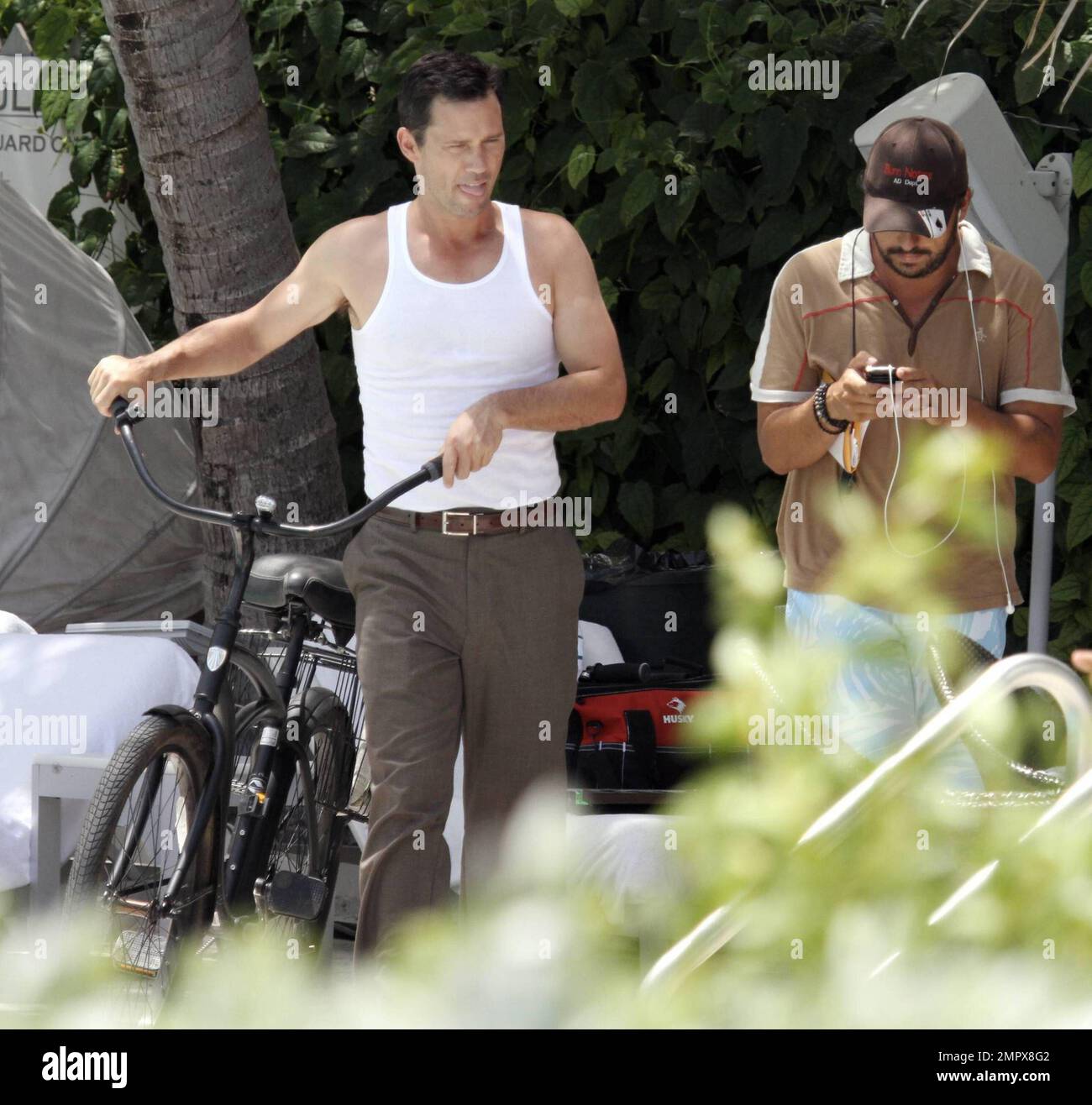 EXKLUSIV!! Burn Notice Schauspieler Jeffrey Donovan springt auf sein Fahrrad am Ende eines Drehtages. Donovan saß auf einem mattschwarzen Retro-Trek-Bike und trug eine Hose und ein weißes Muskel-T-Shirt. Miami, Florida 6/29/10. Stockfoto