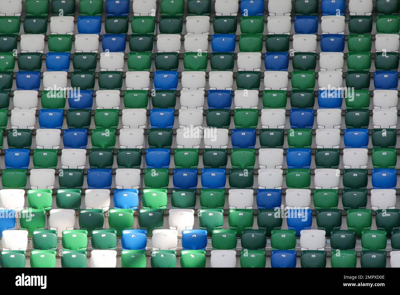Grün-blau-weiße Sitze im Stadion. Reihen moderner Fußballstadion-Klappsitze Windsor Park, Belfast. Stockfoto