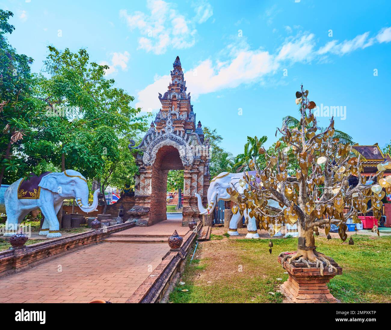 Das Gelände des Wat Lok Moli mit Blick auf das mittelalterliche Ziegeltor, Elefantenstatuen und den goldenen Bodhi Tree, Chiang Mai, Thailand Stockfoto
