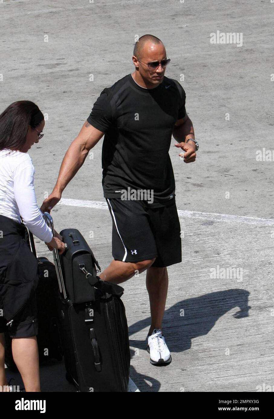 Exklusiv!! Dwayne 'The Rock' Johnson wurde heute Morgen am Flughafen LAX gesehen, als er seine 12-jährige Frau Dany absetzte, zusammen mit ihrer Tochter Simone. Johnson Bär umarmte beide, bevor er zu seinem Auto ging und ging. Los Angeles, Kalifornien. 5/4/09. Stockfoto