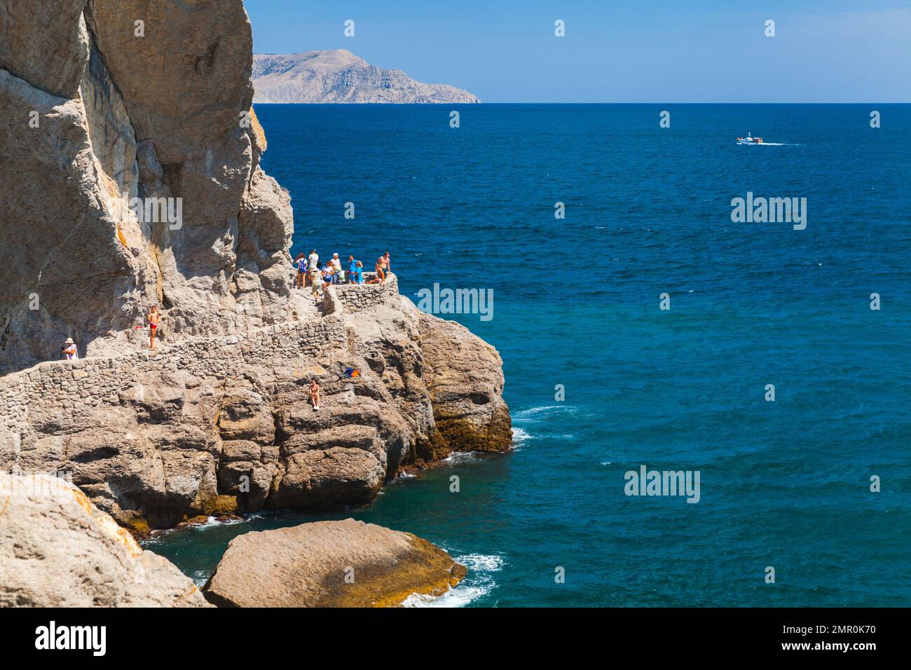 Novy Svit, Krim - 10. August 2020: Touristen laufen an einem sonnigen Tag auf dem Golitsyn Trail. Sommerlandschaft Krim mit Coaral Felsen an einem sonnigen Tag. Novyi Stockfoto