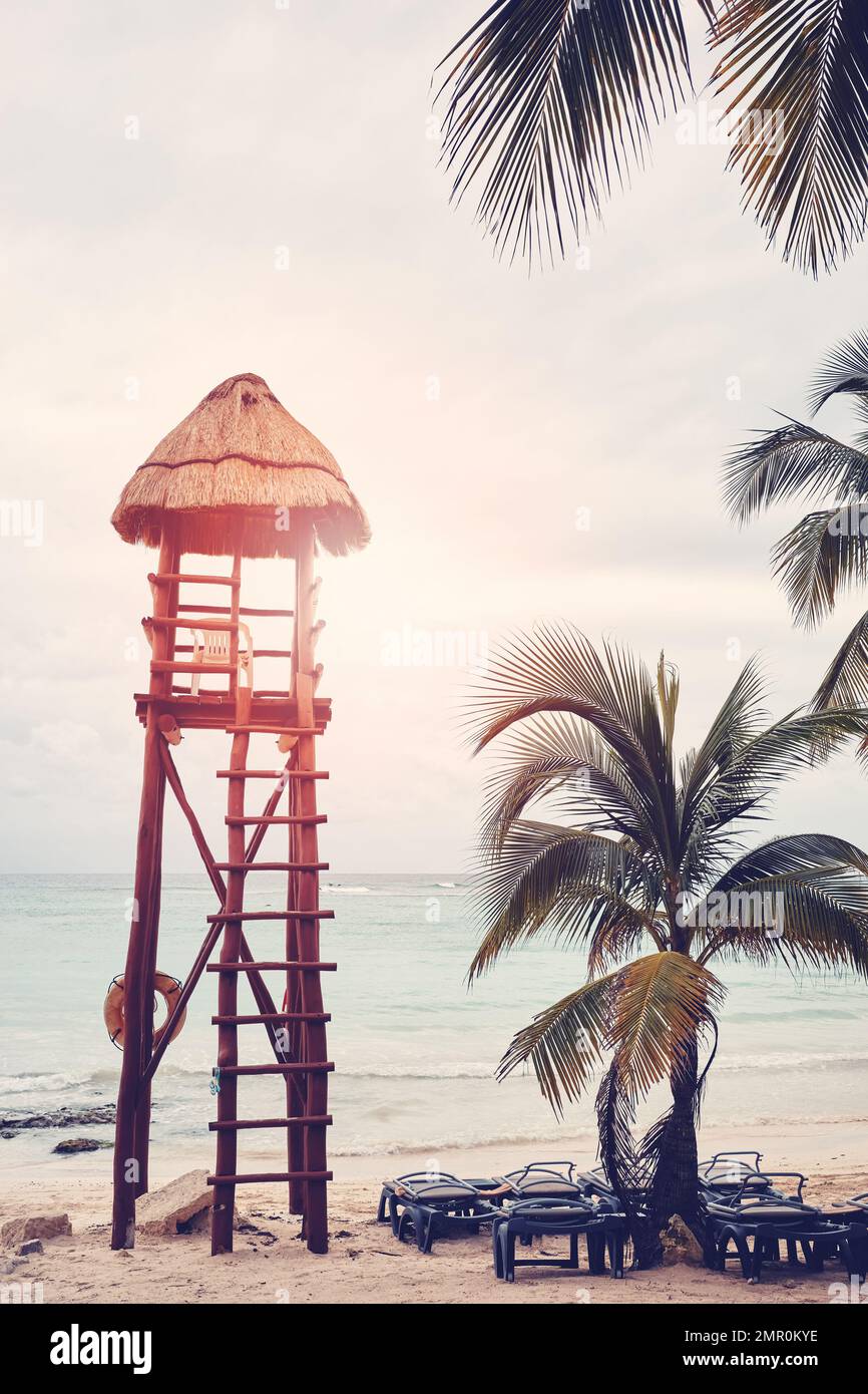 Retro-Bild eines leeren tropischen Strands mit Rettungsschwimmturm, Reisekonzept. Stockfoto
