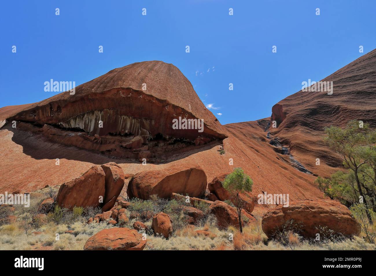 452 Abflusslinie von trockenen Wasserfällen – riesige Rissblöcke am Fuße der gerillten südöstlichen Seite des Uluru-Ayers Rock. NT-Australien. Stockfoto