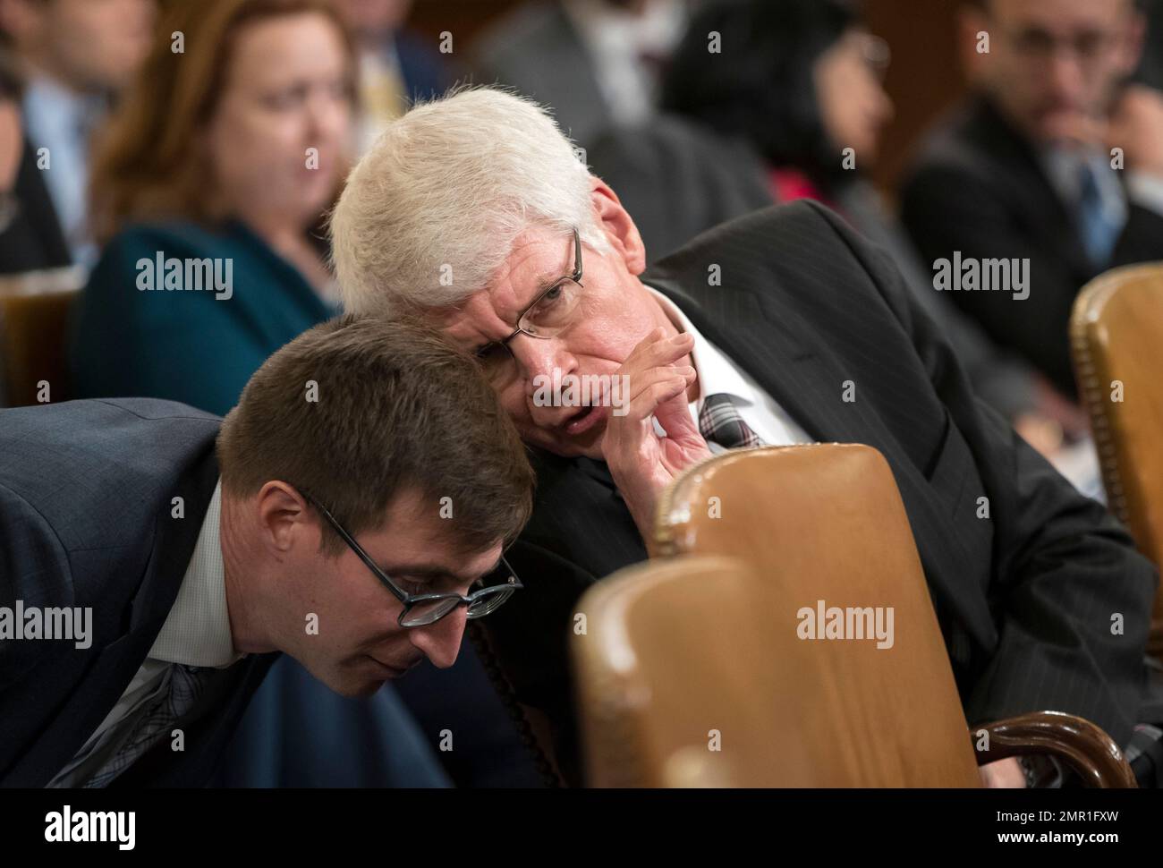 Thomas Barthold, chief of staff for the Joint Committee on Taxation, confers with an aide as he responds to questions from members of the House Ways and Means Committee as the panel begins the markup process of the GOP's far-reaching tax overhaul, on Capitol Hill in Washington, Monday, Nov. 6, 2017. (AP Photo/J. Scott Applewhite) Stockfoto