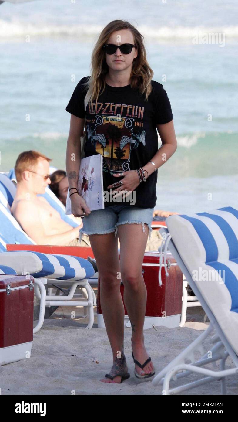 UK Radio One DJ, Fearne Cotton, entspannt sich an einem stürmischen Tag im Sand von Miami. Cotton blätterte durch Zeitschriften und zeigte ihre mehrfachen Tattoos. Sie trug ein Paar Jeansshorts und ein LED Zeppelin-T-Shirt. Miami Beach, FL 1/7/10 Stockfoto