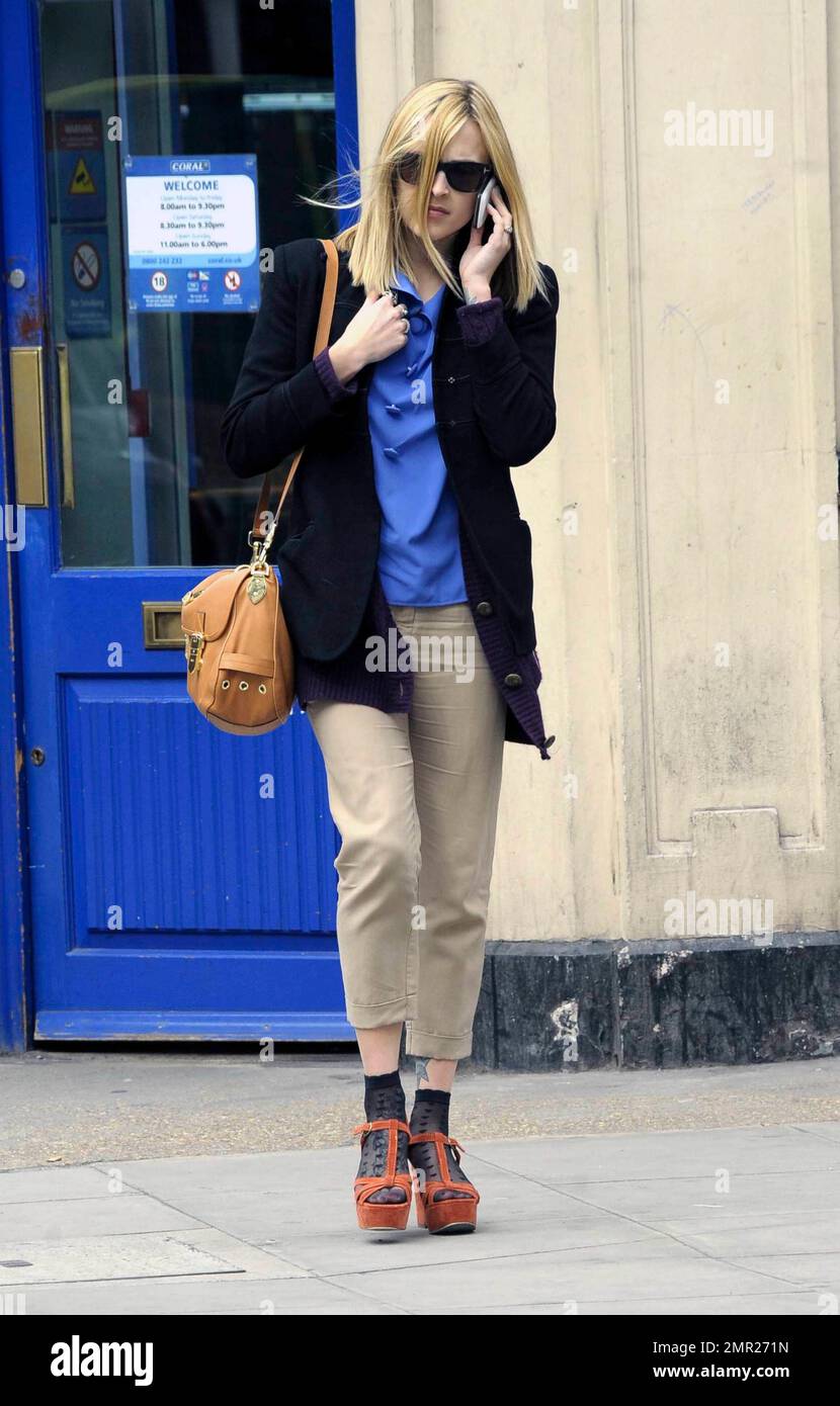 Fearne Cotton chattet mit ihrem Handy und trägt Khaki-Hosen, eine schwarze Jacke und ein blaues Hemd in Kombination mit Sandalen mit Absatz und kurzen Knöchelstrümpfen, wenn sie die BBC verlässt. London, Großbritannien. 3/22/11. Stockfoto