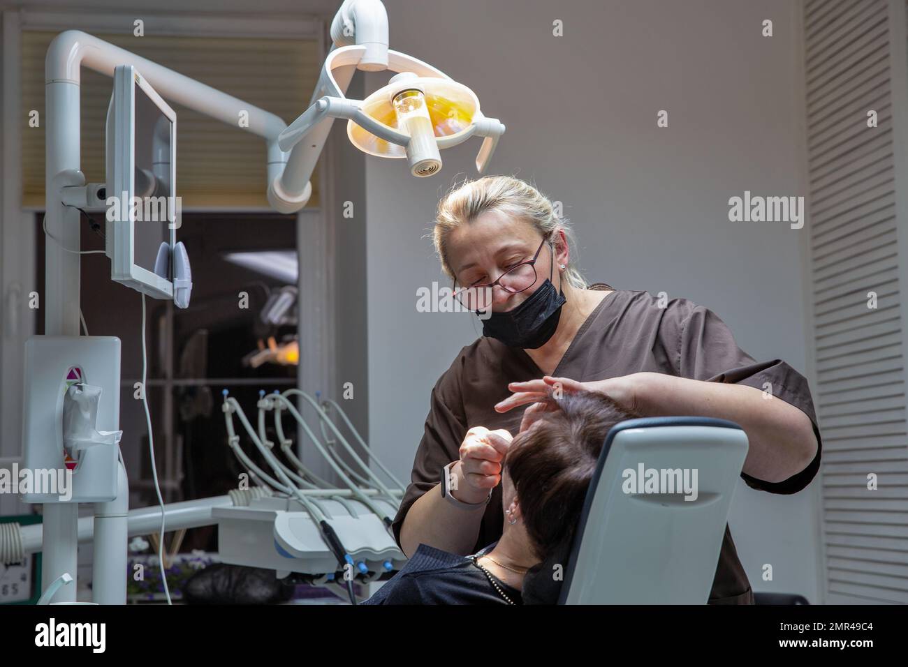 Kiew, Ukraine - 24. Dezember 2022: Zahnarzt, der mit einem Patienten in einer Zahnarztpraxis mit verschiedenen zahnärztlichen Instrumenten und Hilfsmitteln zur Behandlung zusammenarbeitet. Stockfoto