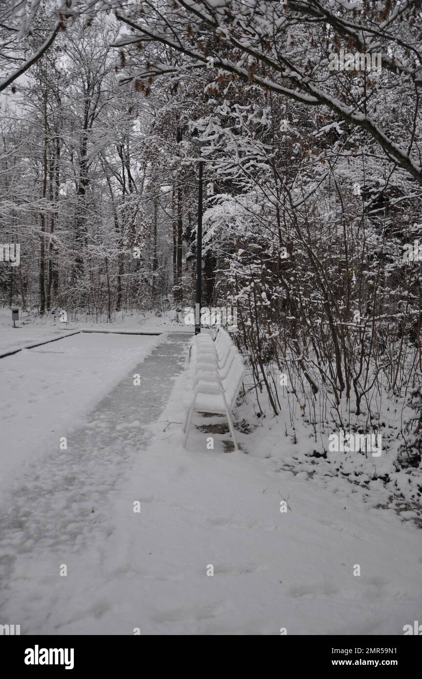 Sessel in einem verschneiten Garten in den Bergen. Verschneite Gartenmöbel, symbolisieren den Winter, Winterurlaub, Halt. Stockfoto