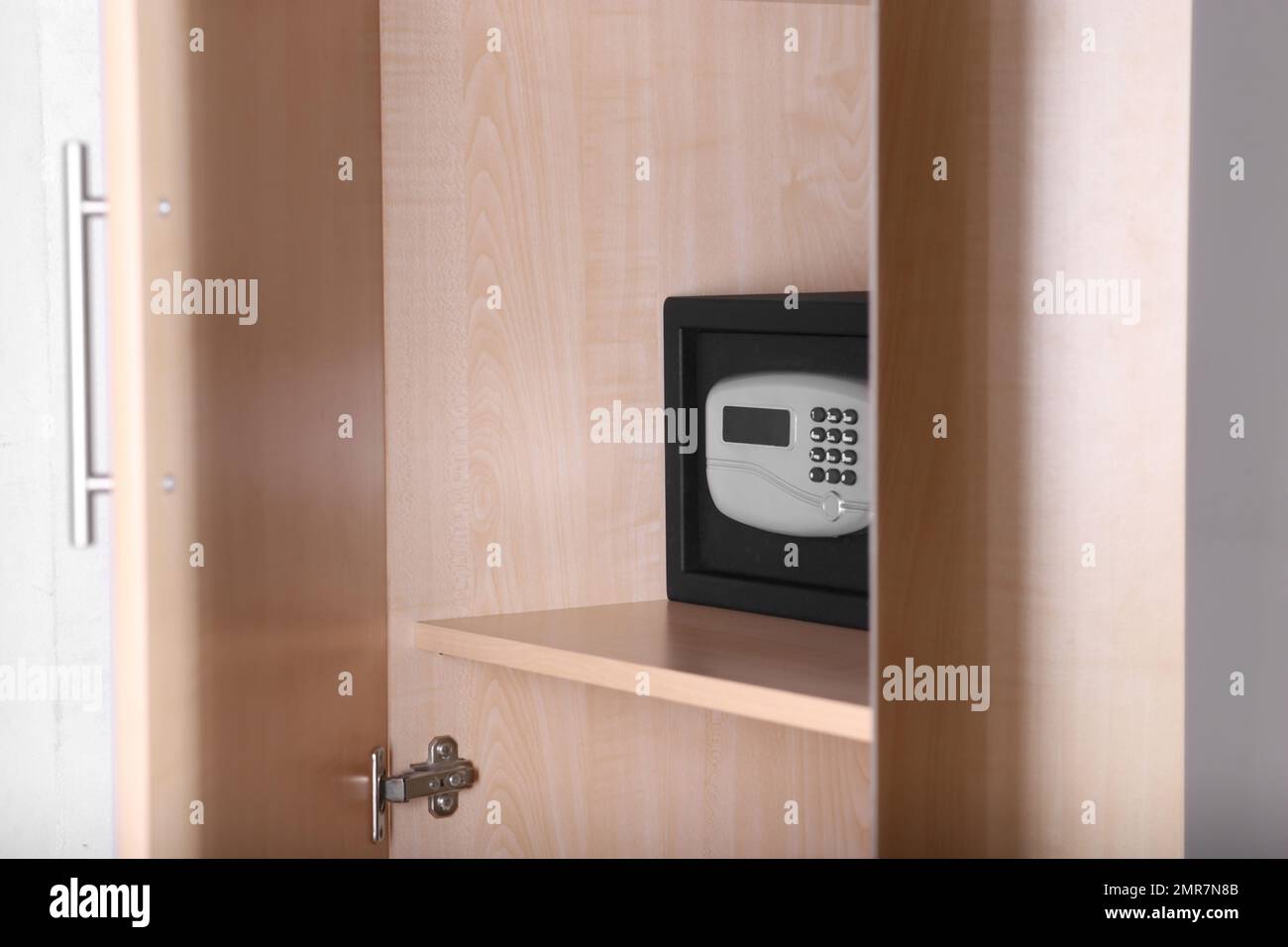 Schwarzer Stahlsafe mit elektronischem Schloss im Holzschrank im Hotel Stockfoto