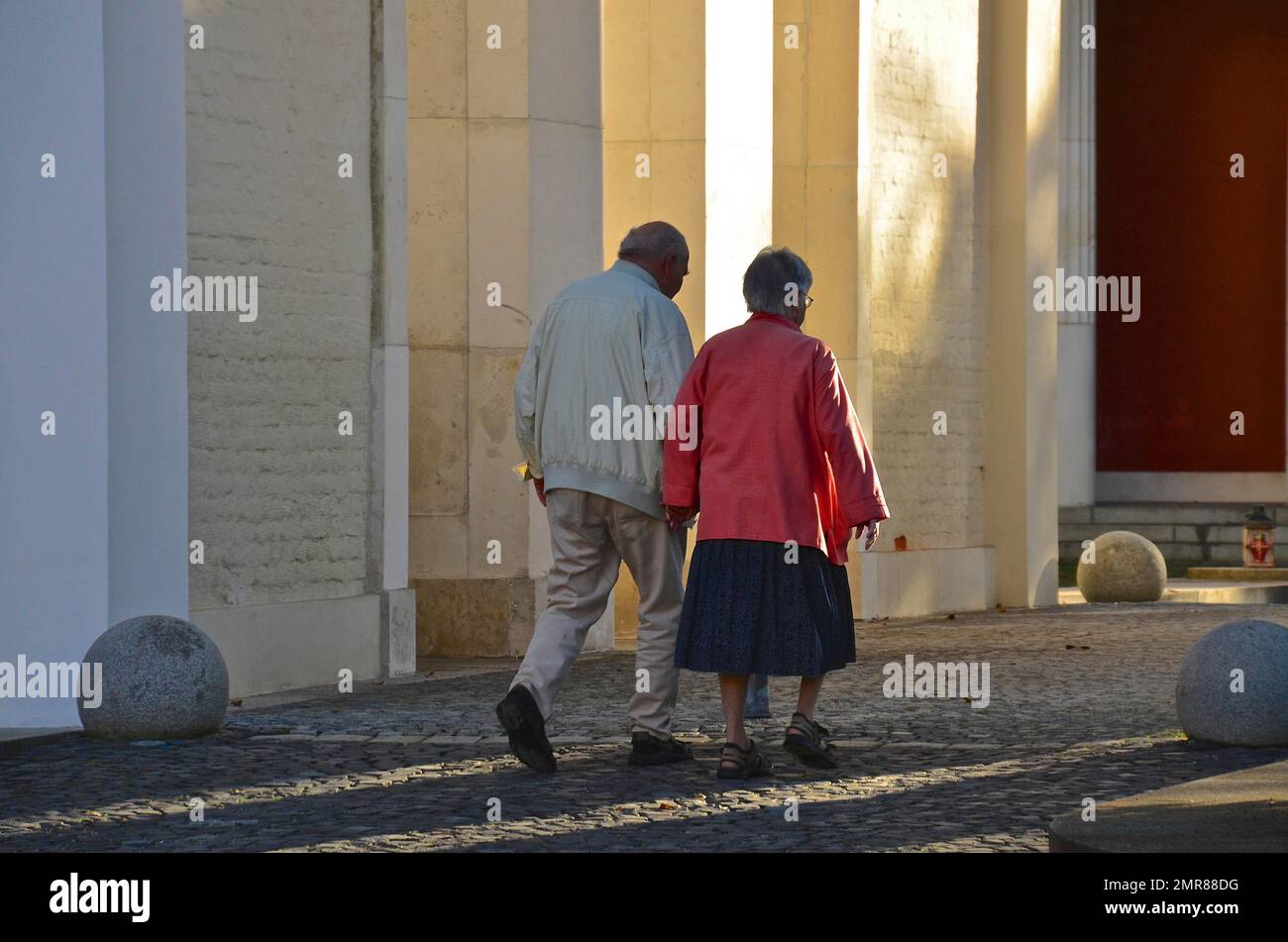 Altes Paar, das Hand in Hand vor Ostfriedhof, München, Bayern, Deutschland, Europa läuft Stockfoto