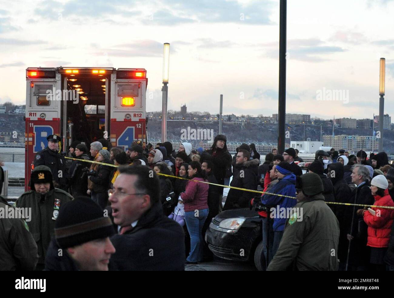 Umstehende Personen versammeln sich und retten vor Ort, nachdem US Airways Flug 1549 Airbus A320 eine Notlandung im Hudson River gemacht hat, nachdem er Berichten zufolge eine Herde von Gänsen getroffen hat, wodurch das Flugzeug beide Triebwerke verloren hat. Jeder im Flugzeug überlebte und wurde von örtlichen Fähren gerettet, die nur Sekunden nach dem Unfall am Tatort waren. New York, NY. 1/15/09. Stockfoto