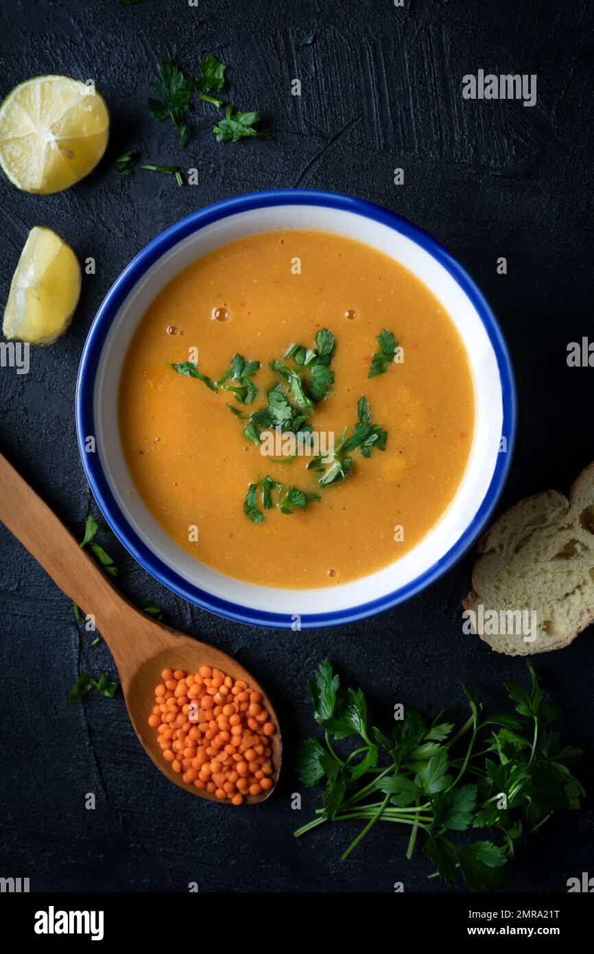 Rotes Linsensuppenpüree in einer Schüssel mit dunklem Hintergrund. Traditionelle Küche aus dem Nahen Osten. Veganes Essen. Stockfoto