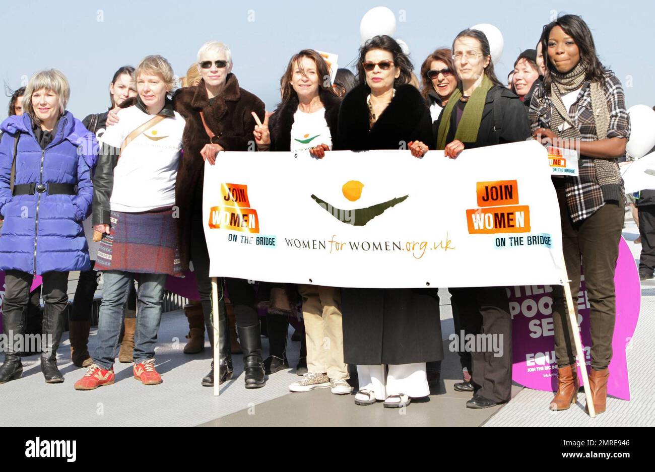 Jude Kelly, Annie Lennox, Cheri Lunghi, Bianca Jagger und Dr. Helen Pankhurst gehen während der zweiten jährlichen Kampagne „Join me on the Bridge“, bei der am Internationalen Frauentag weiße Tauben freigelassen wurden, Seite an Seite mit anderen Frauen mit Schildern auf der Millennium Bridge. Unter den Frauen war Dr. Helen Pankhurst, der sagte: "Es ist mir eine Ehre, an der "Join Me on the Bridge" -Kampagne teilzunehmen, mit Frauen auf der ganzen Welt stark zu sein und Gleichberechtigung zwischen den Geschlechtern zu fordern, Wie es meine Urgroßmutter vor 100 Jahren tat,“ und sich dabei auf Emmeline Pankhurst bezog, eine englische politische Aktivistin und Anführerin der B Stockfoto