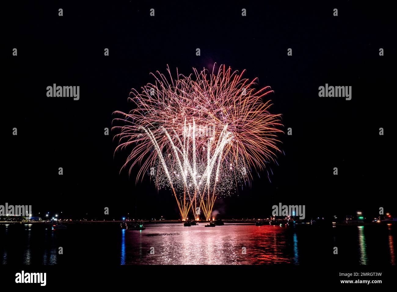 Ein malerischer Blick auf farbenfrohe Feuerwerksproben über dem Hafen von Queen Anne's Battery bei Nacht Stockfoto