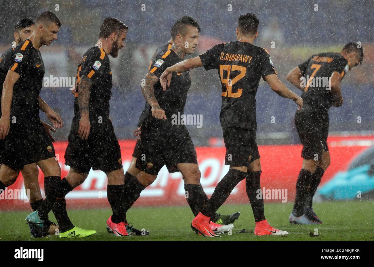 Roma's Radja Nainggolan, center, celebrates with teammates after scoring under heavy rain, during a Serie A soccer match between Roma and Hellas Verona, at the Rome Olympic Stadium, Saturday, Sept. 16, 2017. (AP Photo/Andrew Medichini) Stockfoto