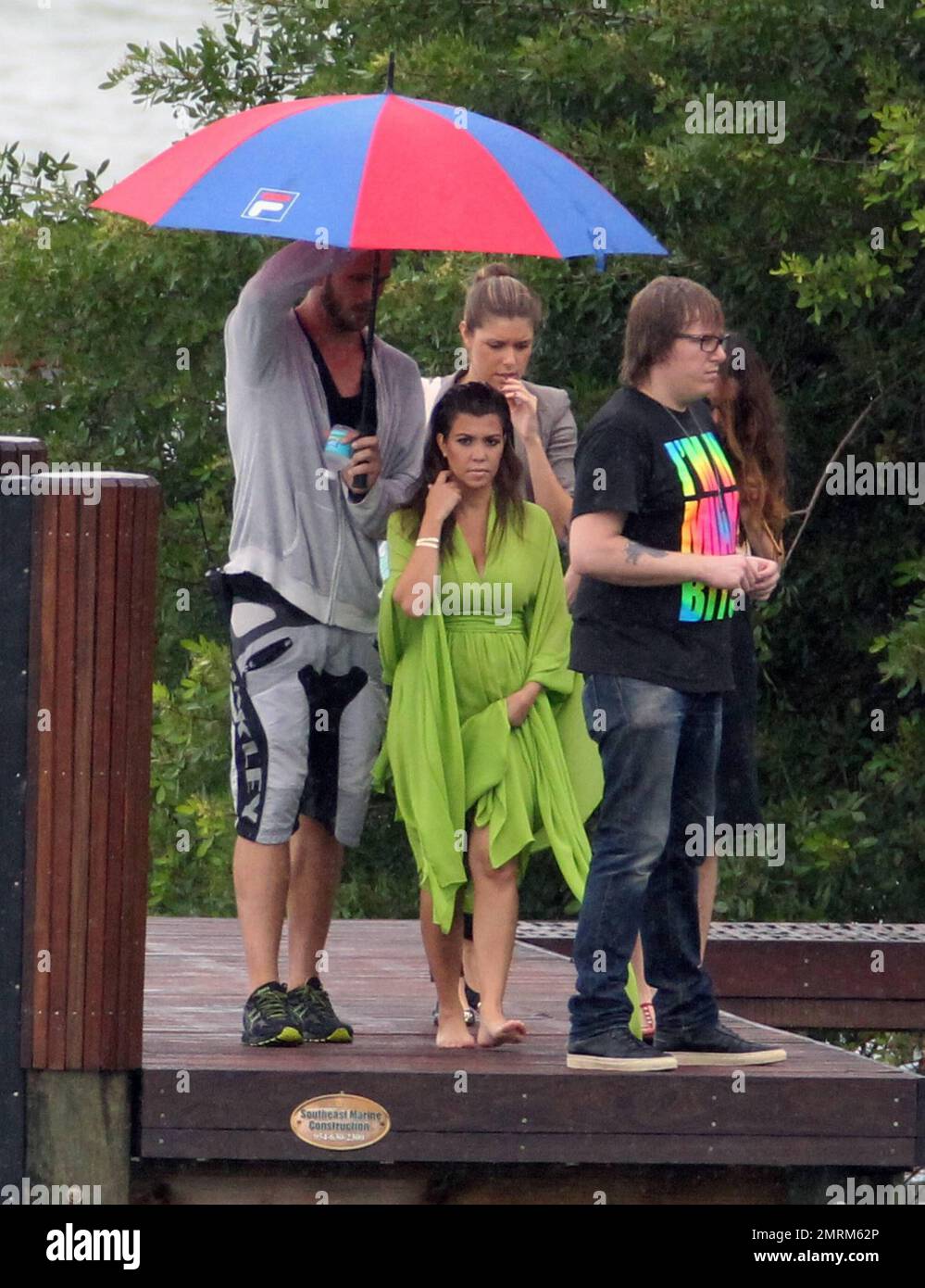 Trotz des starken Windes, des Regens und der starken Brandung durch Hurrikan Sandy's Annäherung, nimmt Kourtney Kardashian an an einem Fotoshooting an der Anlegestelle in Alex Rodriguez Haus in Miami Teil. Kourtney trug ein fließendes limiengrünes Kleid, das manchmal so aussah, als würde es genug Wind fangen, um sie vom Dock ins Wasser zu blasen. Miami Beach, Florida 25. Oktober 2012. Stockfoto