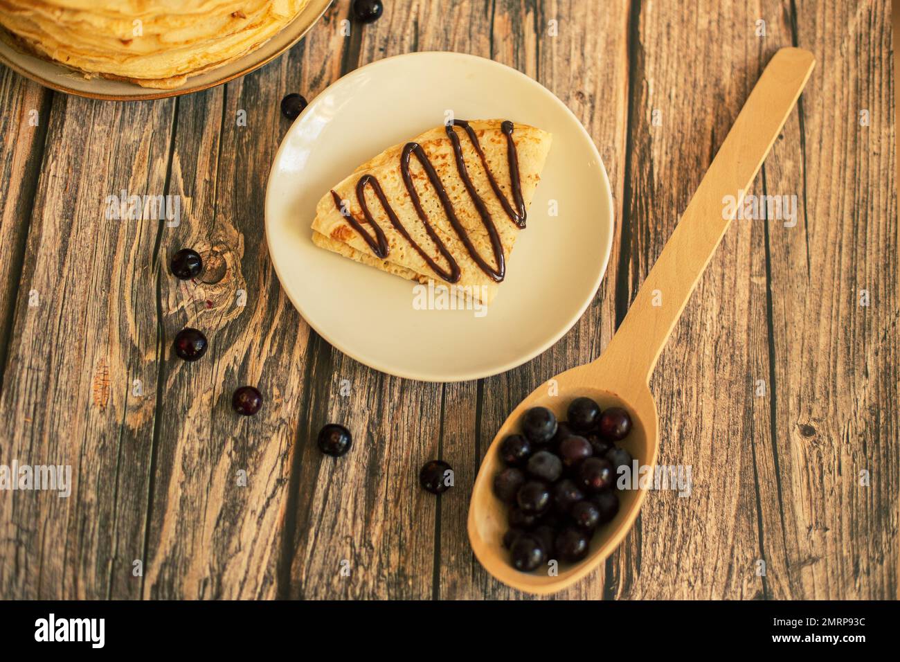 Leckere Pfannkuchen mit Schokoladensauce frische Heidelbeeren auf einem rustikalen Holztisch. Rustikaler brauner Tisch. Stockfoto