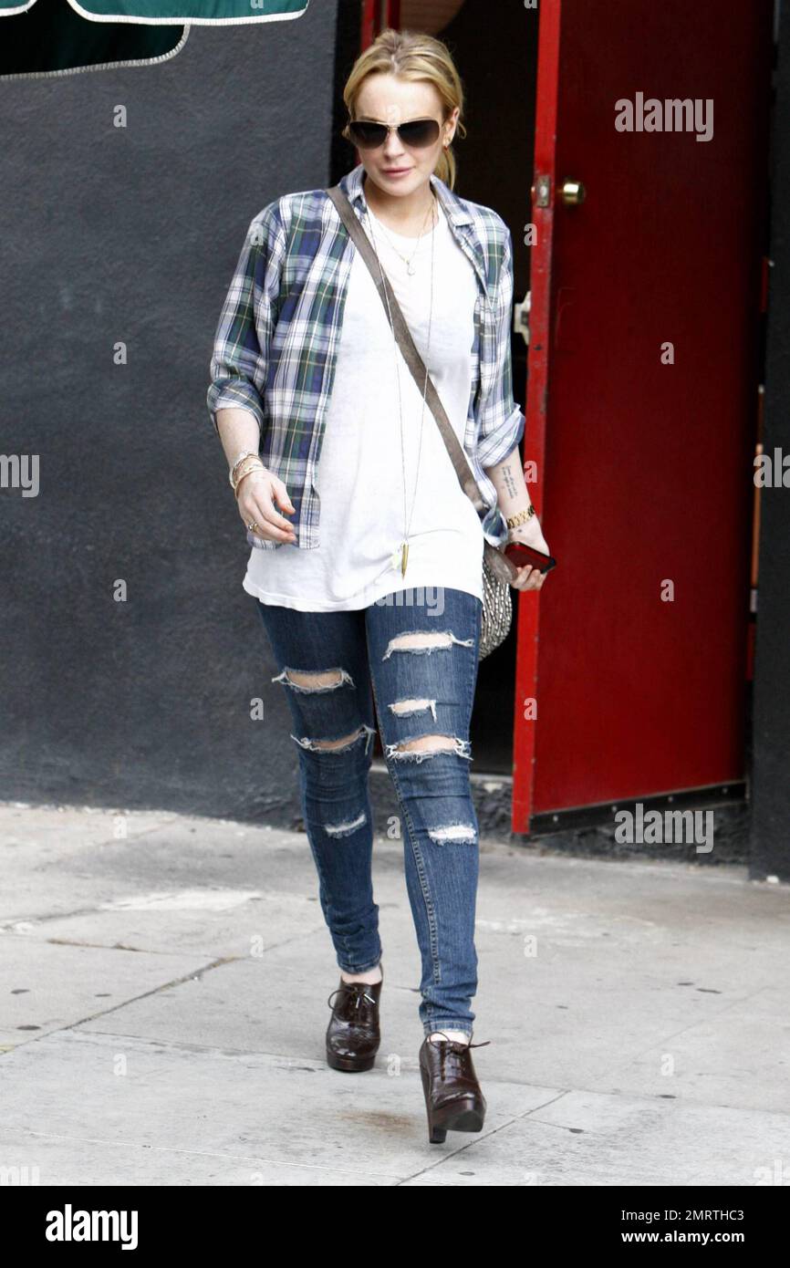 Lindsay Lohan hat eine gerissene Jeans aus den 80ern, während sie Madison, Los Angeles, CA, verlässt, 09/08/10. Stockfoto