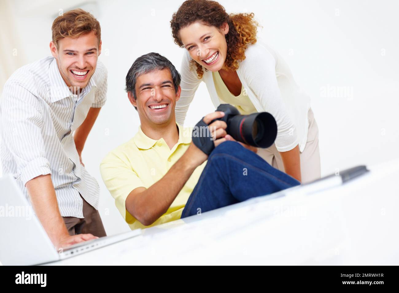 Lächelnde Fotografen. Porträt von drei lächelnden professionellen Fotografen. Stockfoto